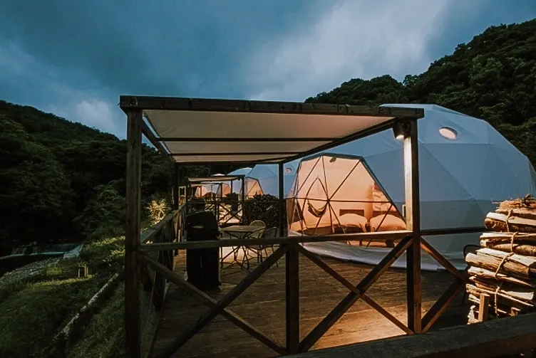 white geodesic domes in front of hill