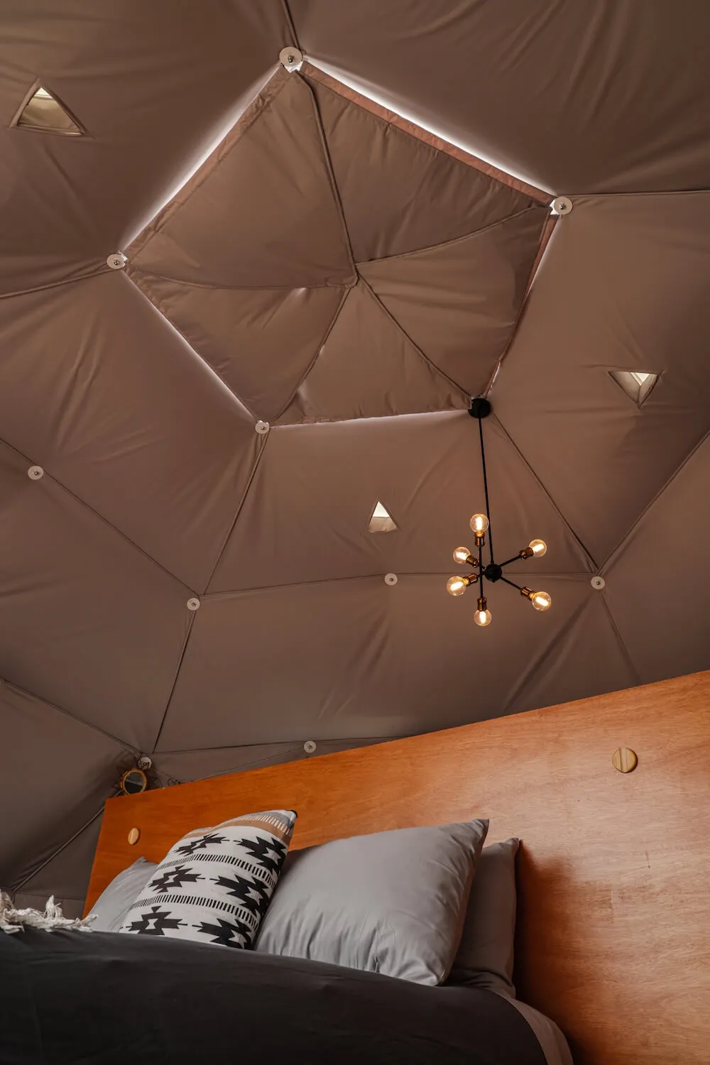 inside of geodesic dome with closed skylight and a bed