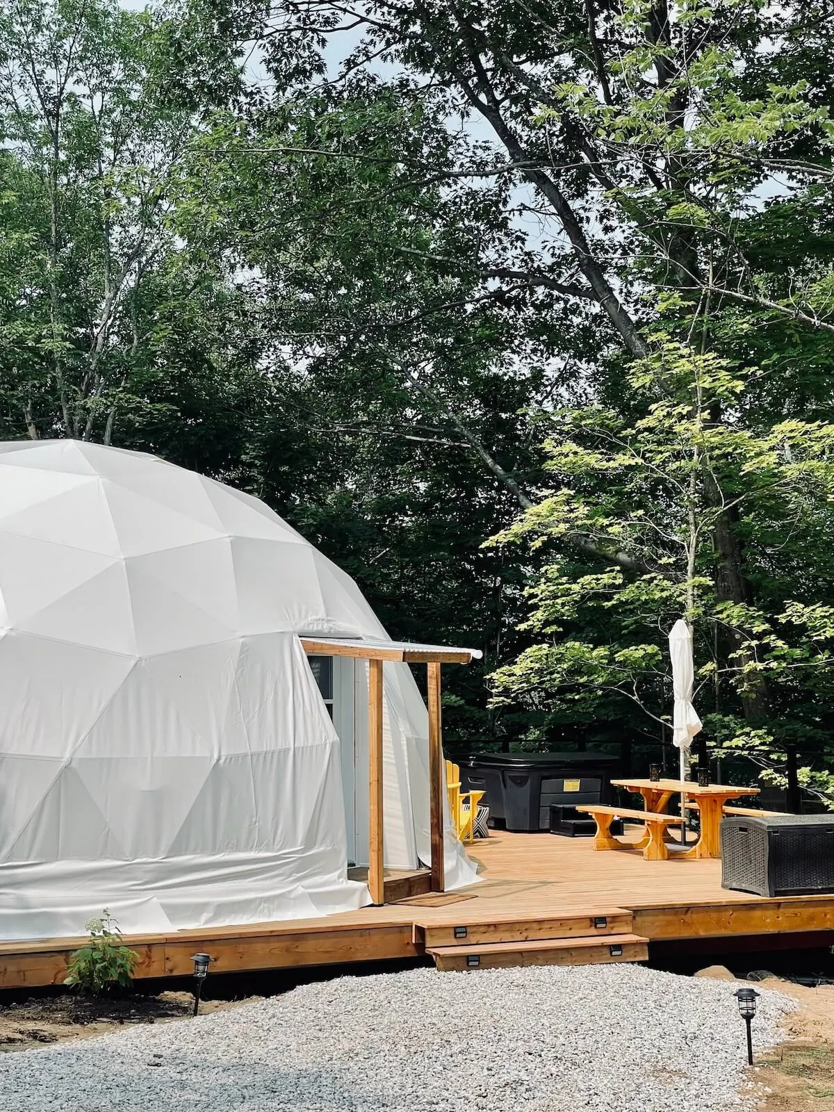 white geodesic dome on wooden deck in the forest