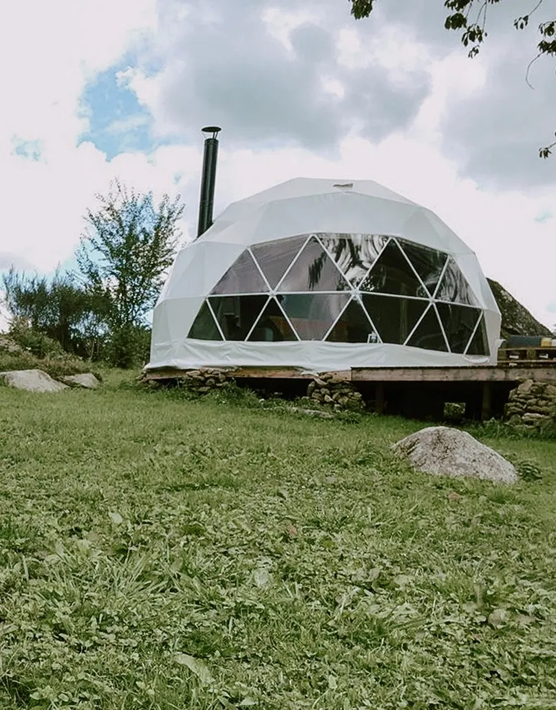 inside of geodesic dome with a sofa and a view on field