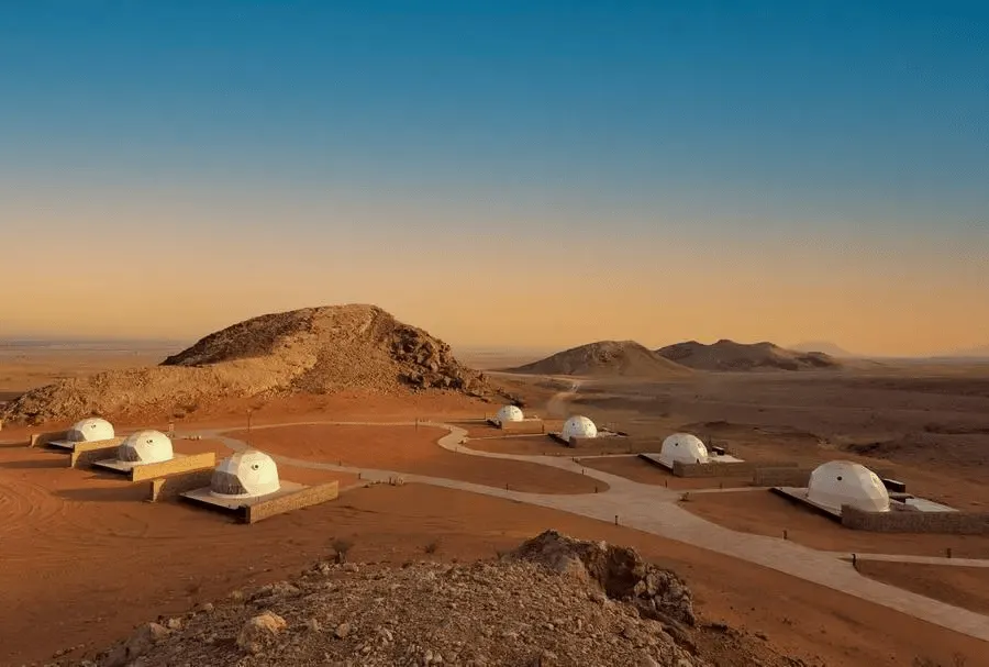seven white geodesic domes on the campsite located on desert
