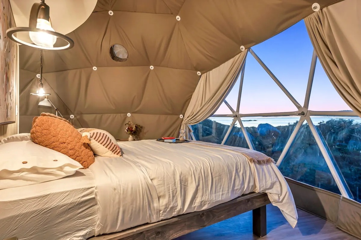 inside of geodesic dome with a bed and a window