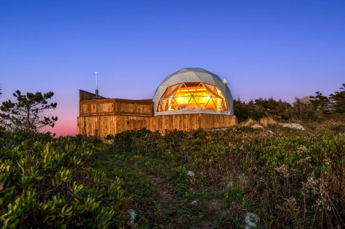 white geodesic dome on wooden deck at night