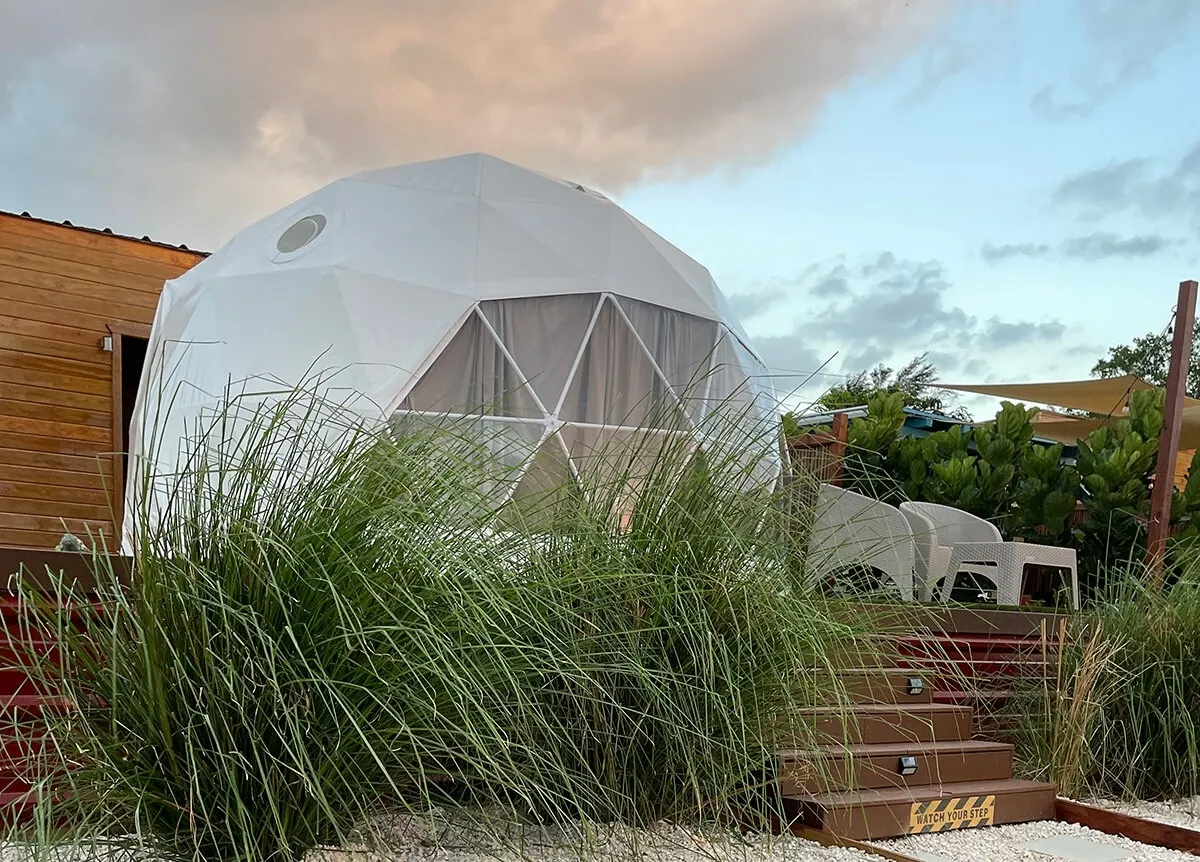 white geodesic dome on wooden deck