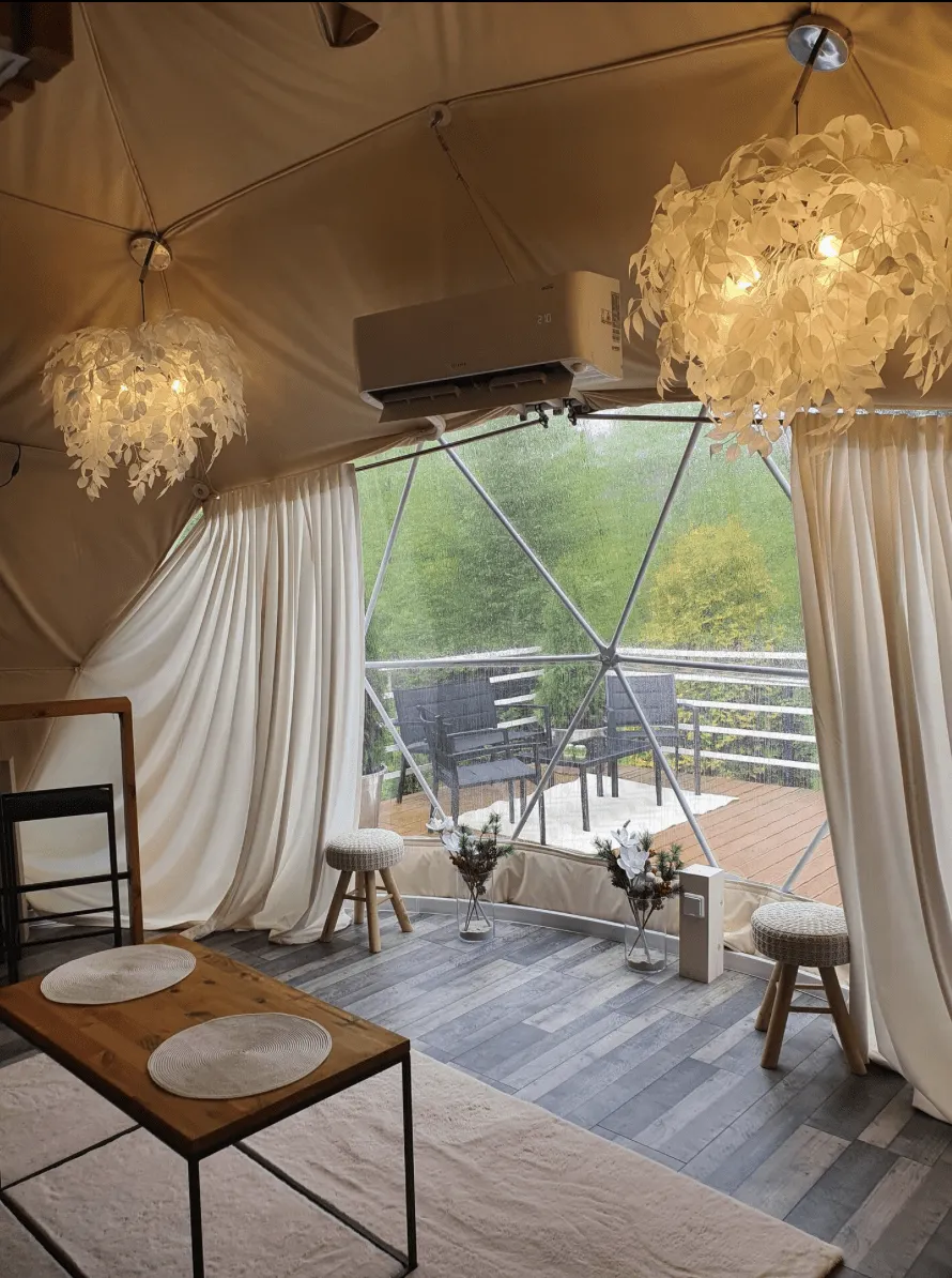 inside of geodesic dome with a big window and a table