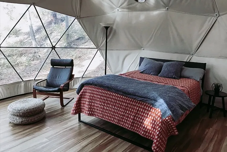 Interior of geodesic dome with view of window and bed