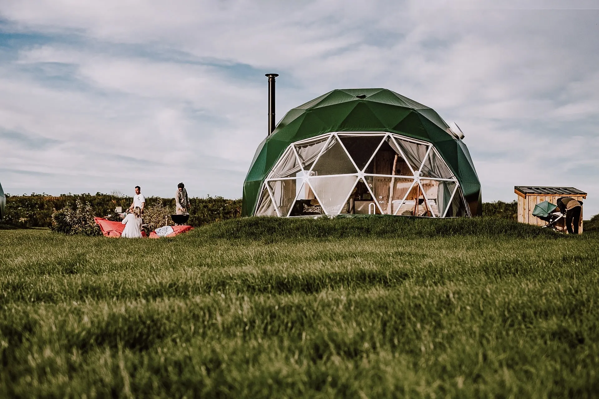 green geodesic dome with stack with people
