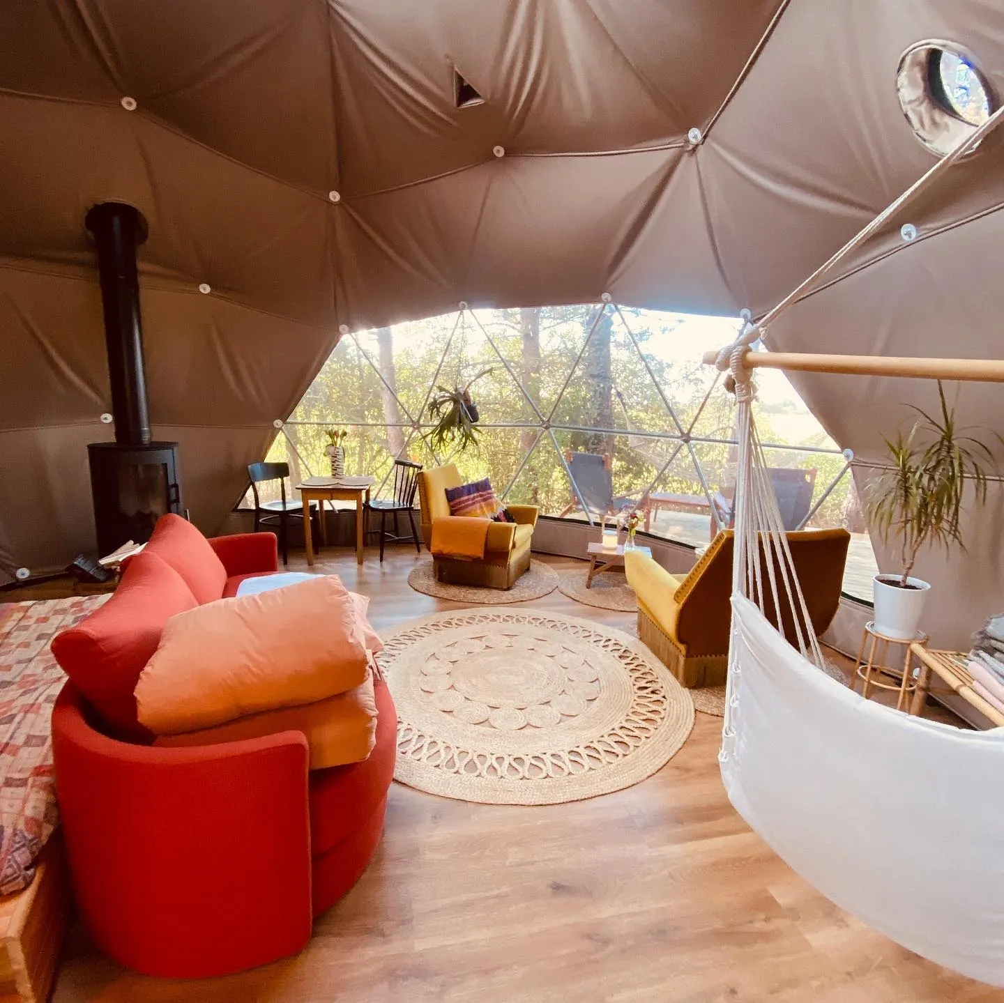 inside of geodesic dome with some chairs, a stove and a window